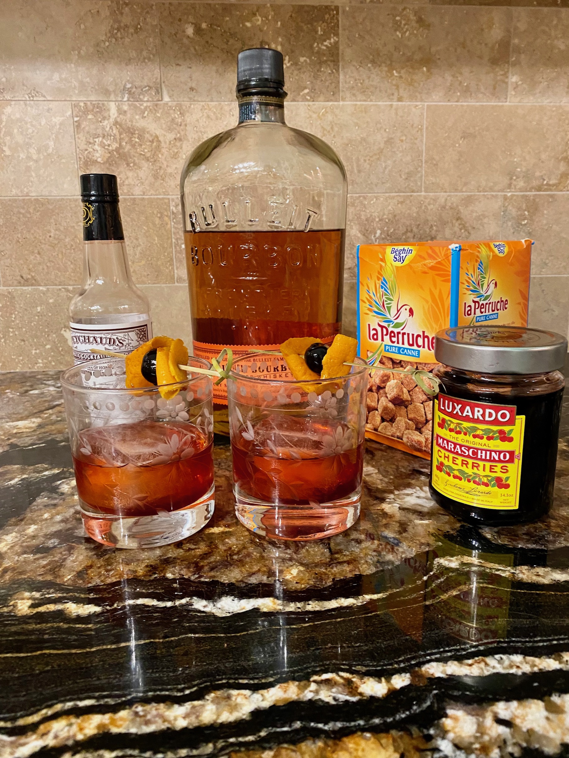 Old fashioned cocktail with bourbon, bitters, sugar cubes, and premium cocktail cherries