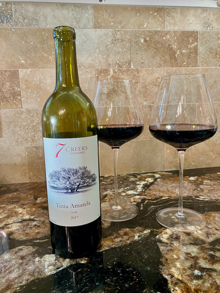 bottle of 7 Creeks Vineyard tinta amarela with two wine glasses of red wine