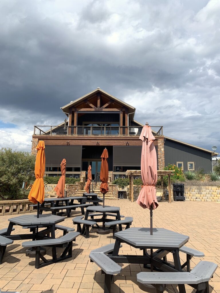 Torr Na Lochs winery patio with tables and orange umbrellas on the Burnet Wine Trail